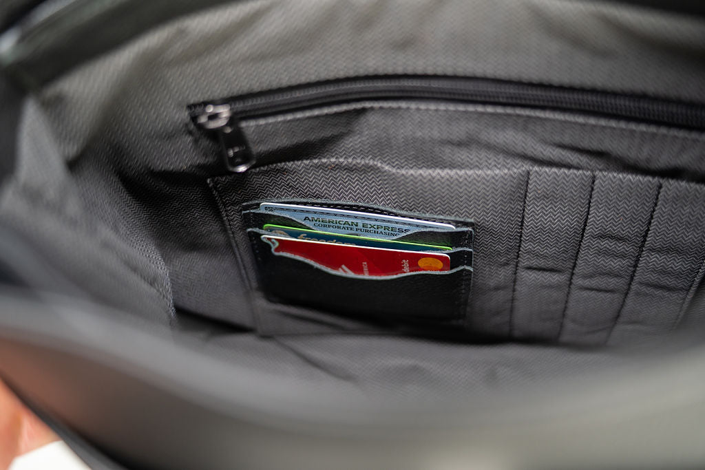 Interior card slots holding cards inside the Artelio black leather crossbody bag