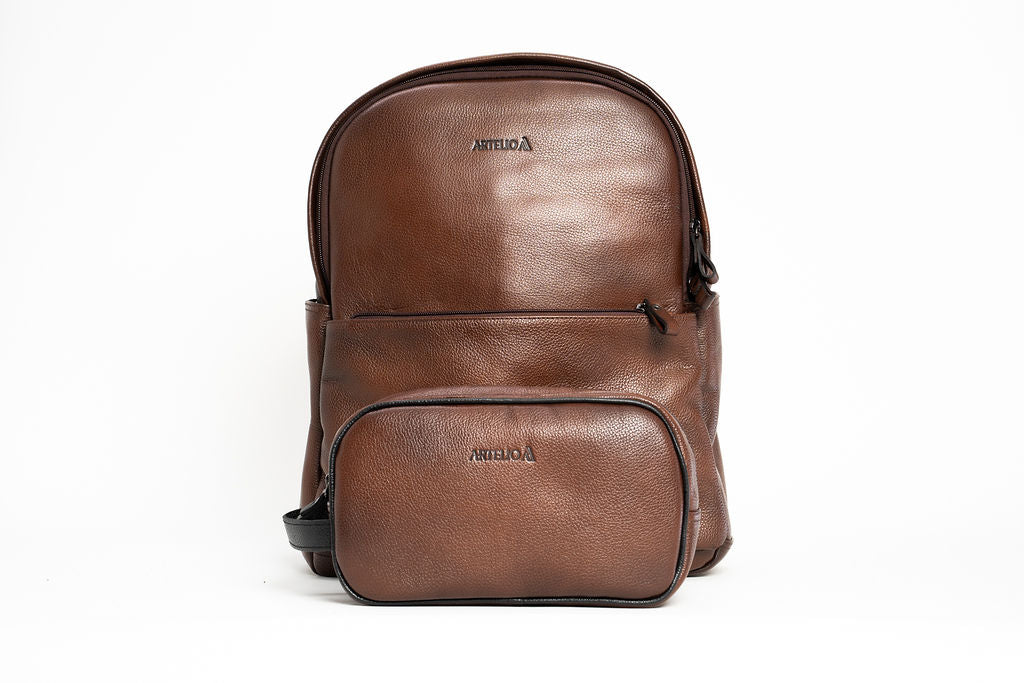 Front view of the Artelio brown leather backpack with zippered front pocket and top carry handle