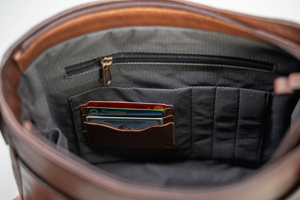 Interior card slots holding cards inside the Artelio brown leather crossbody bag