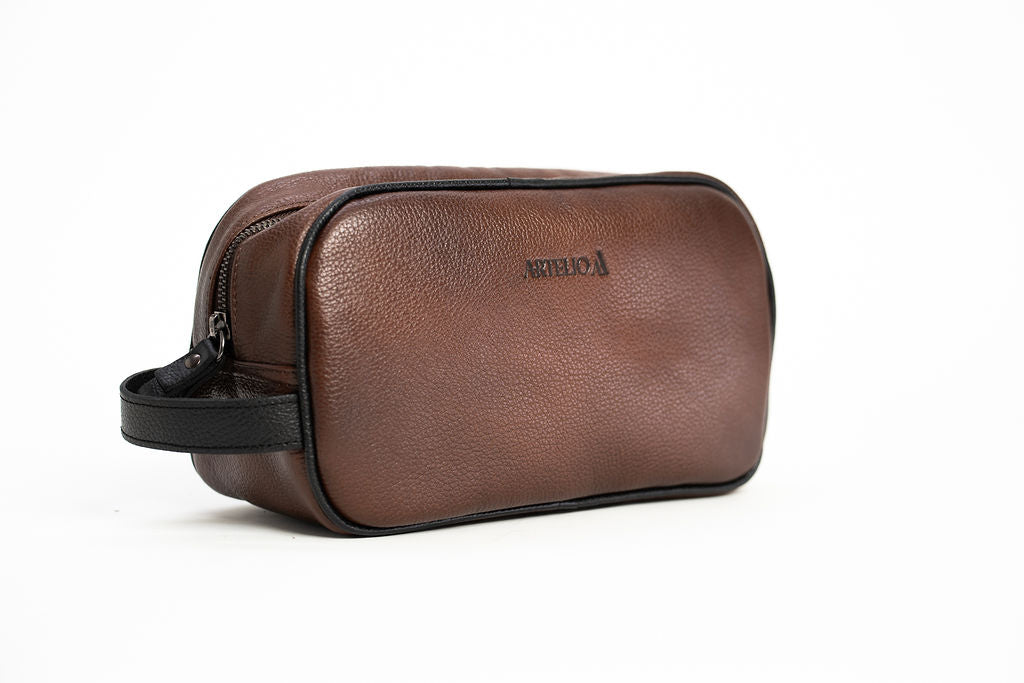 Front angle of the Artelio brown leather dopp kit showing its top handle and structured shape