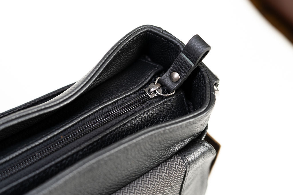 Top opening detail of the Artelio black leather crossbody bag showing the zippered main compartment
