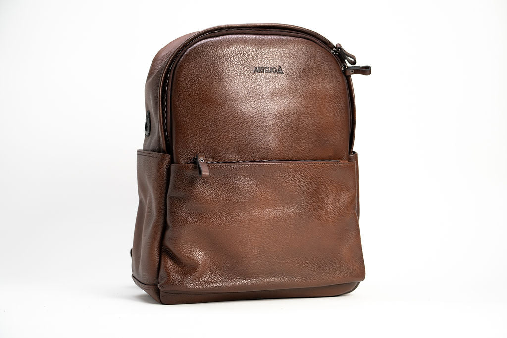 Front view of the Artelio brown leather backpack with zippered front pocket and top carry handle