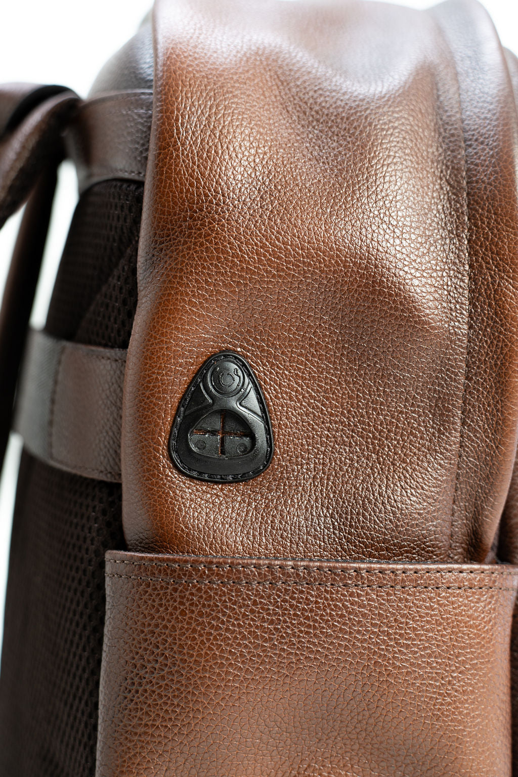 Side profile detail of the Artelio brown leather backpack showing the strap hardware and side pocket