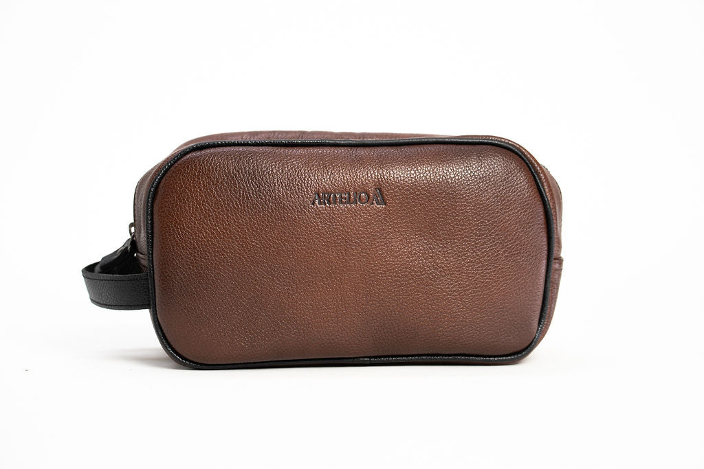 Front view of the Artelio brown leather dopp kit showing the embossed logo and zippered closure