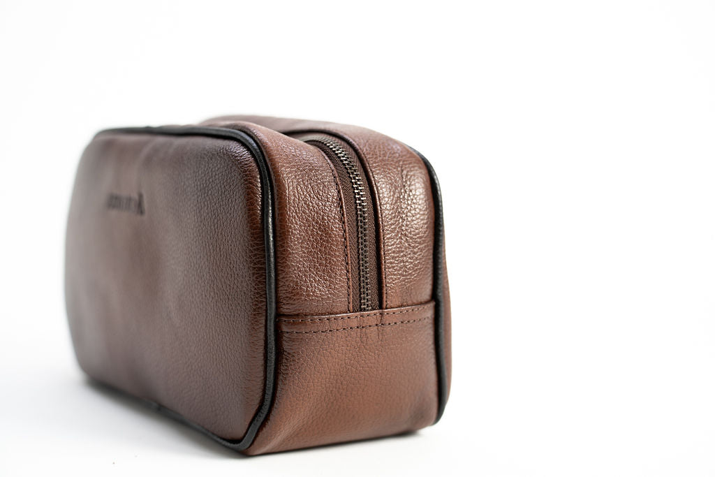 Rear angle of the Artelio brown leather dopp kit showing its structured rectangular shape