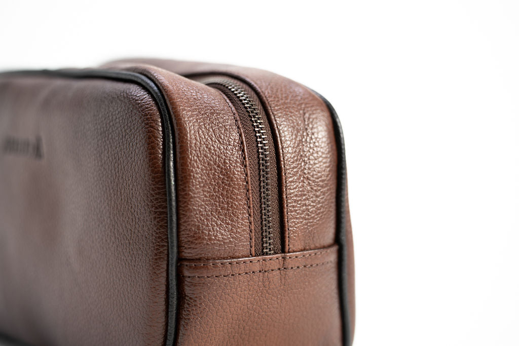 Close-up of the dual zipper tracks and side handle on the Artelio brown leather dopp kit