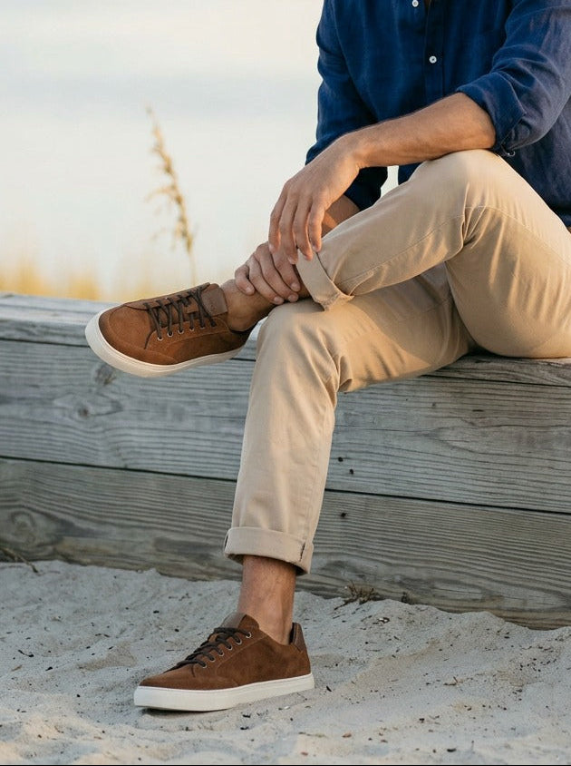 Lifestyle image of the Artelio Elasticore cognac nubuck sneaker styled near the water