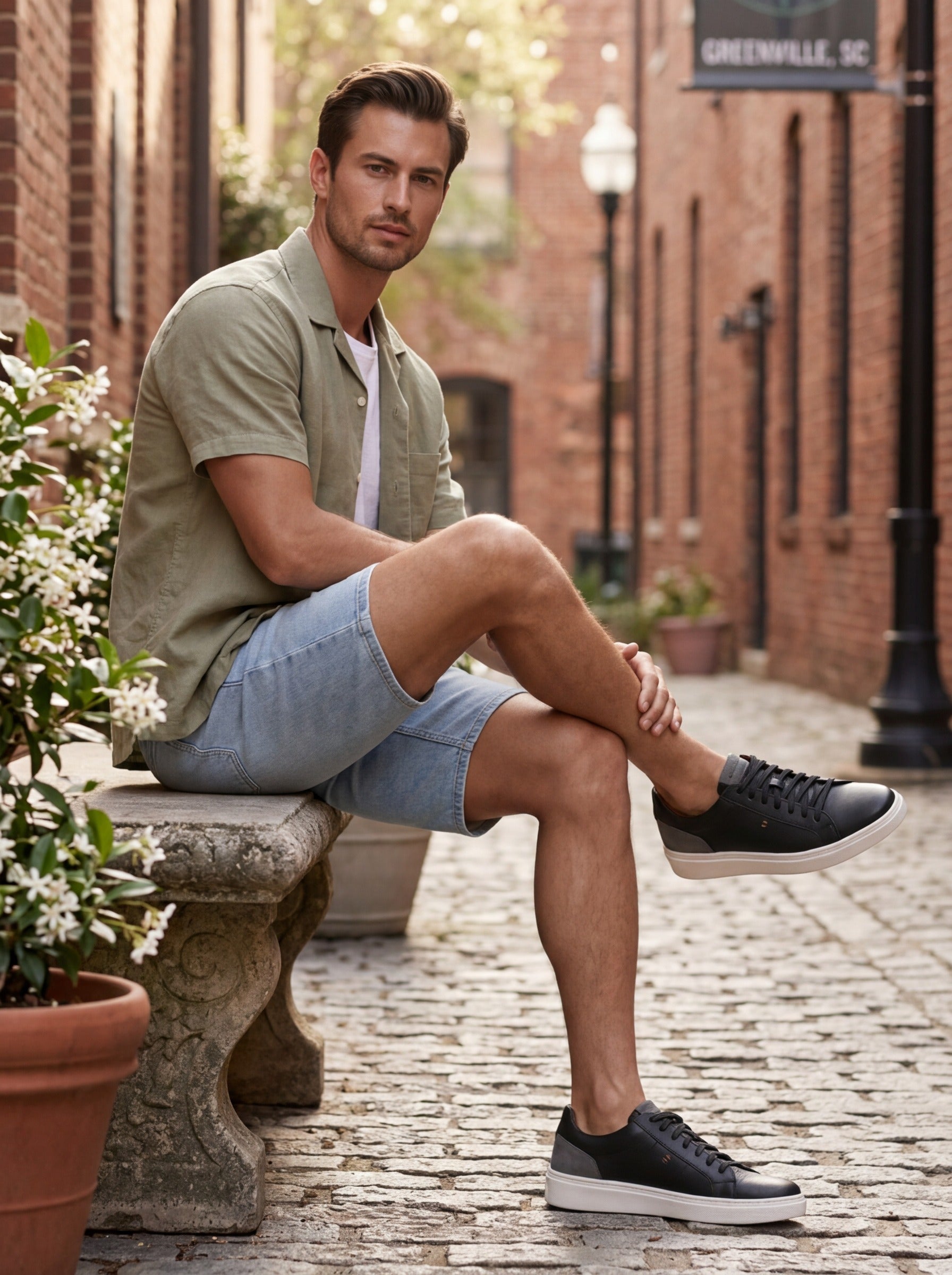 Lifestyle image of the Artelio Heritage black and gray leather sneaker styled with shorts